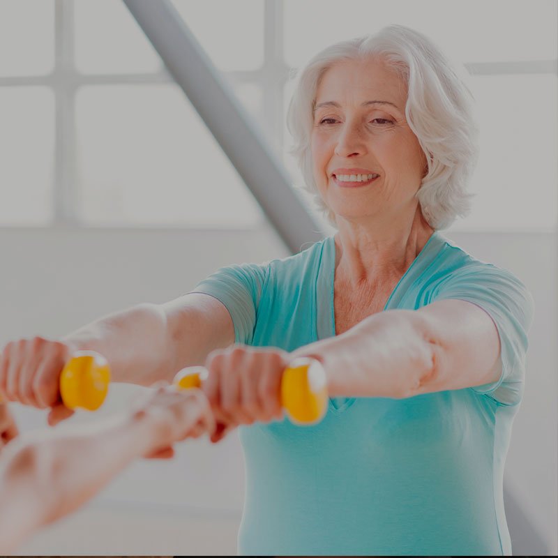 Mujer mayor haciendo ejercicio con mancuernas ligeras